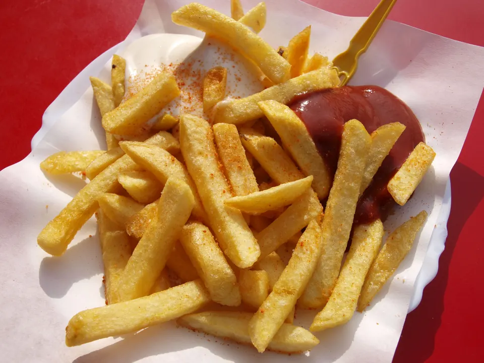 Frites met mayonaise en ketchup op een papieren bordje